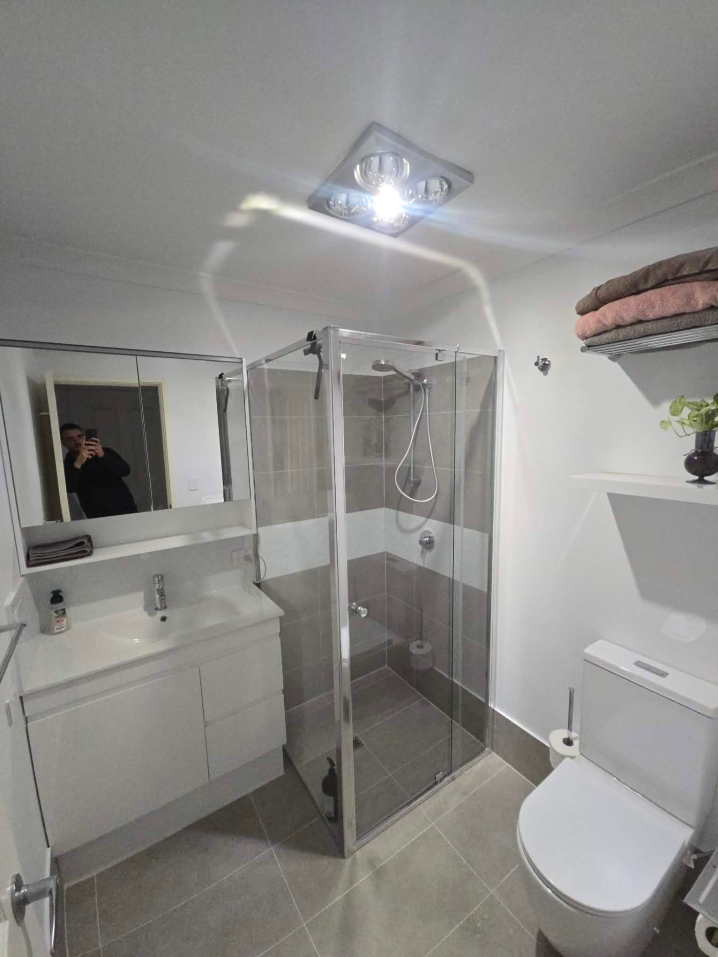 Renovated Canning Vale bathroom with frameless shower, white vanity and grey tiling by Luxe Flow Plumbing